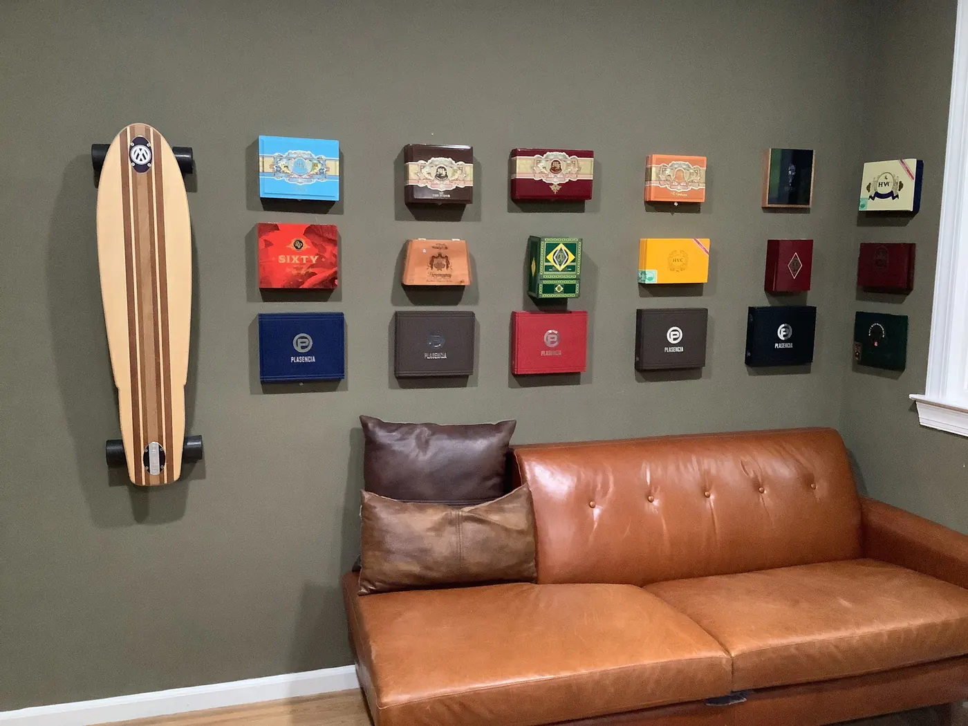 The lounge wall: cigar boxes in a grid above the leather couch.