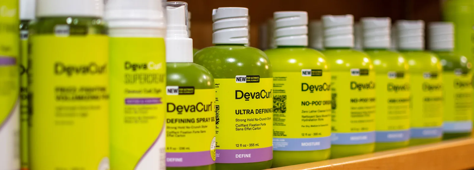 The retail wall, rows of curl products on wooden shelving.