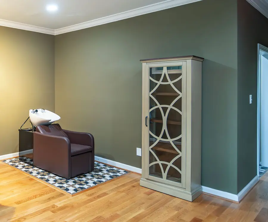 The shampoo chair and product cabinet in the salon room.